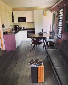 cocina y sala de estar con mesa y sofá en Villa Pheron - De standing - Jacuzzi 5 Personnes en Baie-Mahault