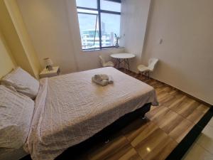 a bedroom with a bed with a hat on it at DerSalvador Sol Victoria Marina Studios in Salvador +35 photos