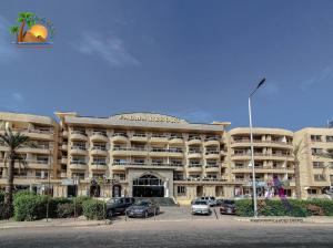 un grand bâtiment avec des voitures garées dans un parking dans l'établissement Apartment, à Hurghada