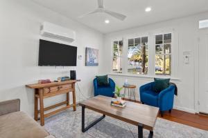 a living room with two blue chairs and a flat screen tv at Downtown Napa HOT TUB Retreat - 3 Bed l 2 bath in Napa