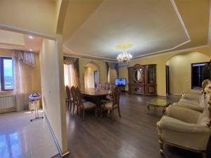 a living room with a table and a dining room at LARGE 5 BEDROOM LUXURY VILLA in Yerevan