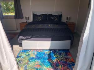 a bedroom with a bed with a colorful rug at Couple’s Lodge With Hot Tub in Lincolnshire