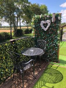 a table and chairs next to a heart wall at Couple’s Lodge With Hot Tub in Lincolnshire