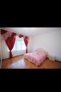 a bedroom with a pink bed and a window at Yan's House in Alaverdi