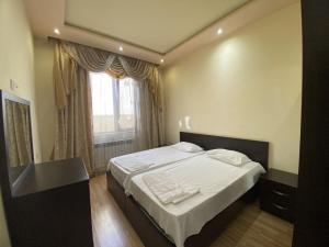 1 dormitorio con 1 cama con sábanas blancas y ventana en LARGE 5 BEDROOM LUXURY VILLA, en Ereván