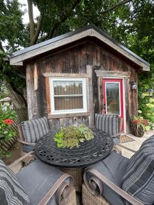 una mesa y sillas frente a una casa pequeña en Cozy Guest House close to Wasaga Beach & Blue Mtn, en Nottawa