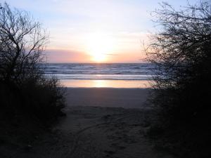a sunset on a beach with the ocean at Playa MaLú in Las Toninas