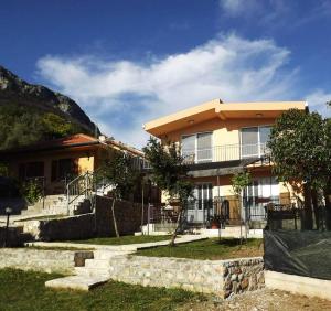 a house with a stone wall in front of it at Apartmani La Vi in Bar