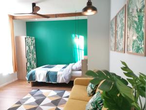 a bedroom with a bed and a couch in a room at Suite Monstera by Welk'Home Inn - Appartement Premium - Troyes Centre in Troyes