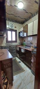 a kitchen with brown cabinets and a counter top at El mansoura Heaven in Bandar al Manşūrah