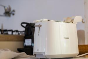 a white toaster sitting on top of a table at MONOLOCALE CASENUOVE con GIARDINO in Castiglioncello