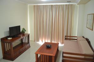 a living room with a couch and a television and a table at Apartamentos Garden Atlantis en Club Atlantis in Adeje