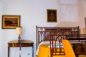 a bedroom with a bed and a yellow table and chairs at MONOLOCALE CASENUOVE con GIARDINO in Castiglioncello