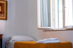 a room with a bed and a window with towels on a table at MONOLOCALE CASENUOVE con GIARDINO in Castiglioncello