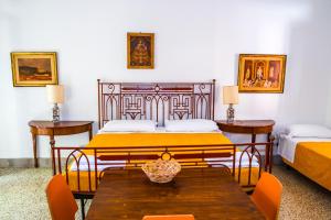 a bedroom with two beds and a table and chairs at MONOLOCALE CASENUOVE con GIARDINO in Castiglioncello