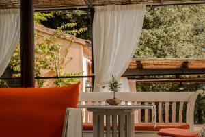 a patio with a table and chairs on a balcony at MONOLOCALE CASENUOVE con GIARDINO in Castiglioncello