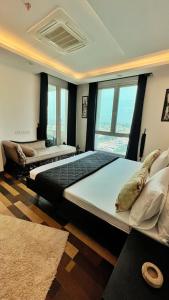 two beds in a room with a large window at Sun-Rise view Luxury apartment Gold Crest Mall in Lahore