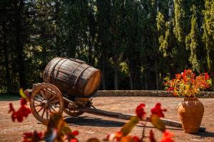 a wooden cart with a barrel next to a vase of flowers at MONOLOCALE CASENUOVE con GIARDINO in Castiglioncello