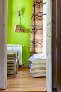 Cette chambre est dotée d'un mur vert et d'un lit. dans l'établissement B&B Quarto Verde Estilo Africano, 
