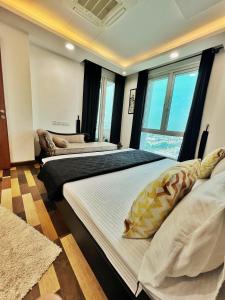 two beds in a room with windows at Sun-Rise view Luxury apartment Gold Crest Mall in Lahore