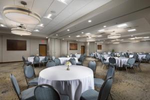 una sala de banquetes con mesas y sillas blancas en The Scenic Hotel at Biltmore Village, en Asheville