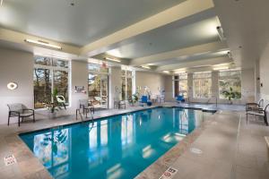 una piscina en un hotel con sillas y mesas en The Scenic Hotel at Biltmore Village en Asheville
