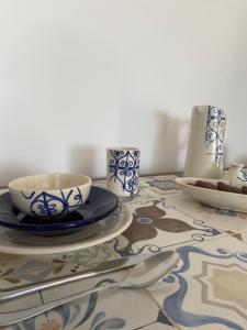 メズライアにあるStudio Bleu Cosy à Dar Lili Djerbaのテーブル上に皿と器具を並べたテーブル