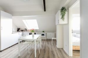 a kitchen and dining room with a white table and chairs at T&K Apartments - 1 to 4 Room Apartments - 20min to TradeFair Messe Airport Düsseldorf in Duisburg