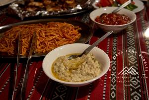 a table with a bowl of dip and a plate of food at Wild Oryx Camp Bubbles in Disah