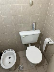 une salle de bain avec des toilettes blanches et un lavabo dans l'établissement Consorcio Cortijo I, à San Juan