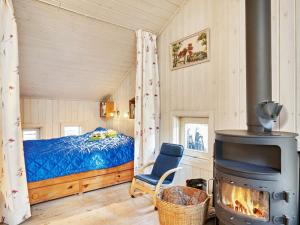 Vester Sømarkenにある8 person holiday home in Nexのベッドルーム1室(ベッド1台、薪ストーブ付)