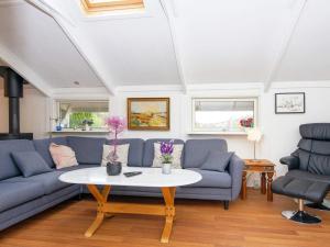 a living room with blue couches and a table at 6 person holiday home in R nde in Rønde