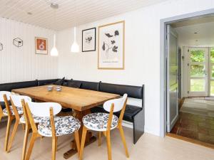 エーベルトフトにある8 person holiday home in Ebeltoftのダイニングルーム(木製テーブル、椅子付)