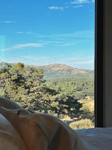 a bedroom window with a view of a mountain at Casa Otea in Ávila