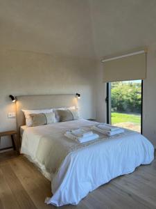 a bedroom with a large white bed with a window at Casa Otea in Ávila