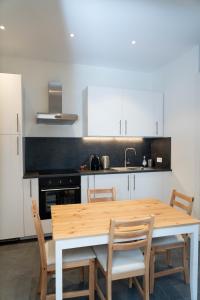 Beau T2 quartier Contades في ستراسبورغ: مطبخ مع طاولة وكراسي خشبية