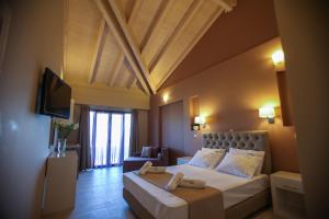 a hotel room with a bed and a television at Tramonto Suites in Xi