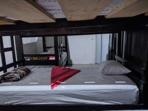 uma cama com um cobertor vermelho num quarto em 59C hostel em Antigua Guatemala