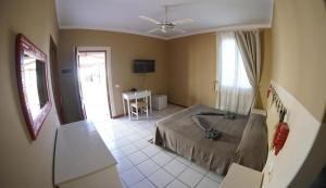 Schlafzimmer mit einem Bett, einem Tisch und einem Fenster in der Unterkunft Estoril Hotel - Apartments in Sal Rei