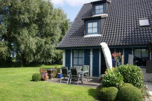 una casa azul con una mesa y sillas en el patio en Ostseewelle, en Schönberger Strand