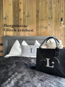 eine schwarze Tasche auf einem Bett in der Unterkunft Das Liftplatzl in Sankt Michael im Lungau