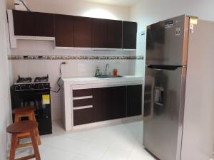 una cucina con frigorifero in acciaio inossidabile e piano cottura di Apartamento amoblado Neiva¡! capacidad 2 personas a Neiva