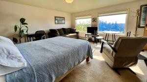 The Peregrine Suite - Comfort and Luxury in the Heart of Kodiak في كودياك: غرفة نوم مع سرير وغرفة معيشة