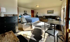 The Peregrine Suite - Comfort and Luxury in the Heart of Kodiak في كودياك: غرفة نوم بسرير وطاولة وكراسي
