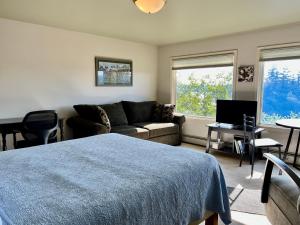 a living room with a bed and a couch at The Peregrine Suite - Comfort and Luxury in the Heart of Kodiak in Kodiak