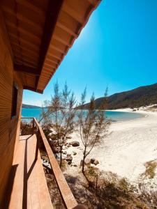 een uitzicht op het strand vanaf de veranda van een huis bij LOFT ORLA PRAIA GRANDE até 5 pessoas in Arraial do Cabo