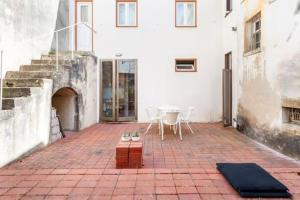 eine Terrasse mit einem Tisch und Stühlen sowie ein Gebäude in der Unterkunft SOBRE RIBAS 12 in Coimbra