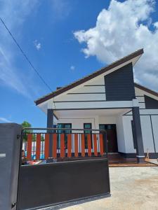 ein Haus mit einem Tor davor in der Unterkunft Homestay Besut in Kampung Raja