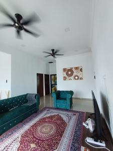 ein Wohnzimmer mit einem Sofa und 2 Stühlen in der Unterkunft Homestay Besut in Kampung Raja