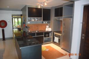 cocina con armarios negros y nevera de acero inoxidable en Kalim Residence, en Patong Beach